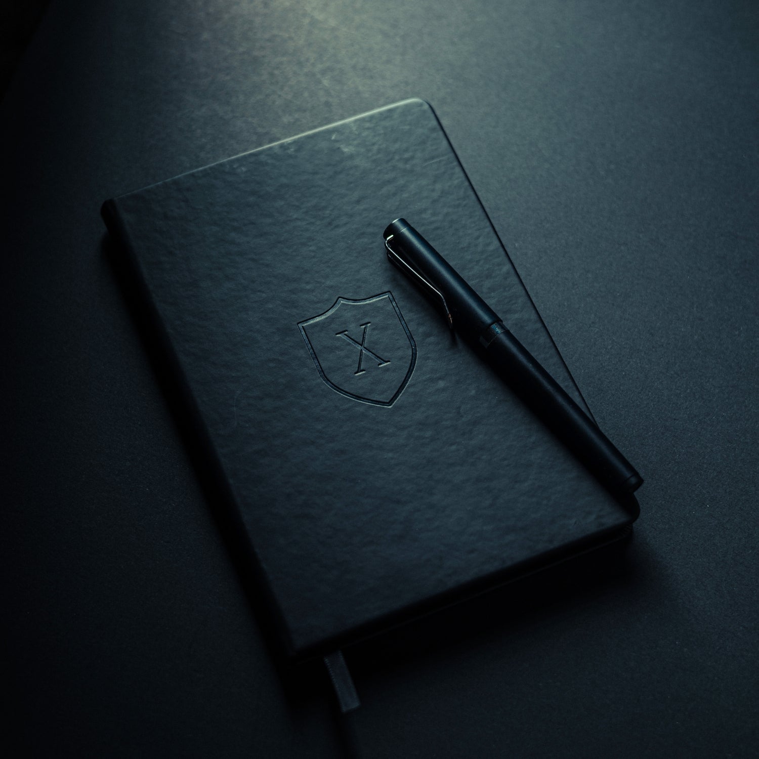 Agenda cuaderno con hojas negras para emprendedores y oficina cerrada con su lápiz